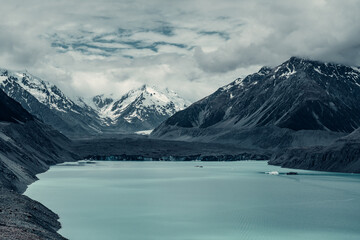 Melted Glacial Field with Lake Surrounded By Snow Covered Mountains in Mount Cook National Park, New Zealand