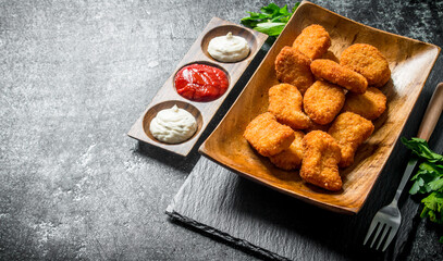 Chicken nuggets with parsley and different sauces.