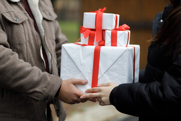 A couple exchange gifts. Beautiful gift. New Year's decor. Preparation for the holiday. Gift on a dark background.
