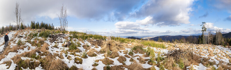 Panorama on the top of the hill with snow and tourists on the countryside.