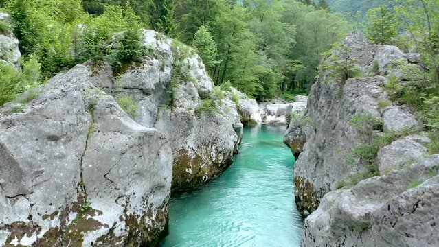 Flying Between Great Soča Gorge With Unreal Emerald Soča River Floating Between Majestic Tolmuns, Cliffs, Canyons In The Middle of Wilderness Surrounded With Huge Stones, Rocks, Forest.    