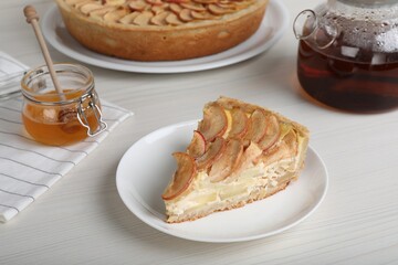 Piece of delicious homemade apple pie served on white wooden table