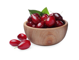 Fresh ripe dogwood berries with green leaves in wooden bowl on white background