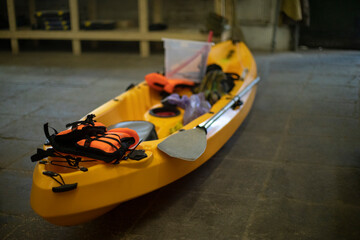 Yellow boat made of plastic. Canoe in garage. Sports equipment.