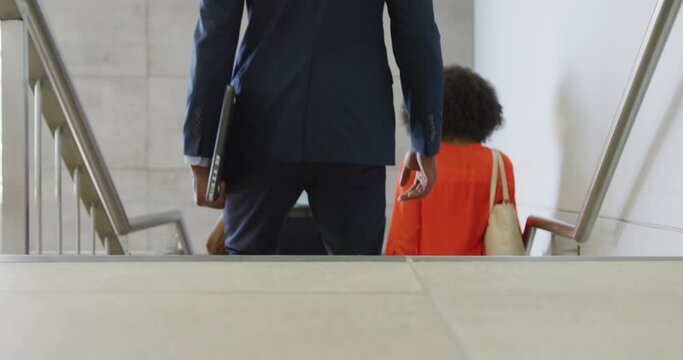 Diverse business people going down stairs at office, slow motion