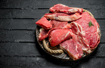 Raw meat. Beef and pork steaks on a wooden tray.