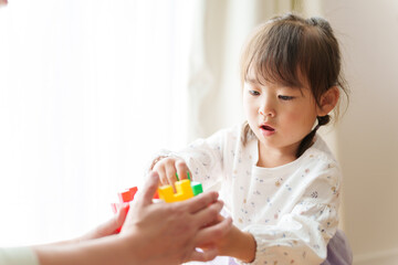 おもちゃで遊ぶ女の子とお母さん