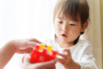 おもちゃで遊ぶ女の子とお母さん