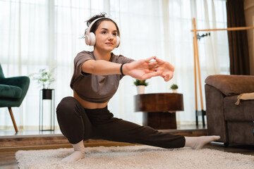 Fototapeta na wymiar One woman training at home young adult female stretching on the floor