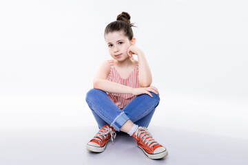 portrait of young adorable girl sit on floor on ground isolated on white with little joyful smile...