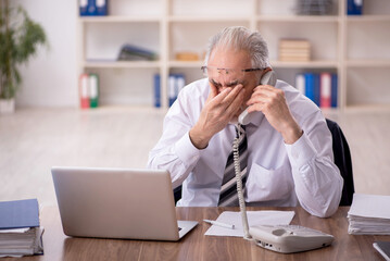 Old male employee working in the office