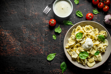 Dumplings with spinach, sour cream and tomatoes.