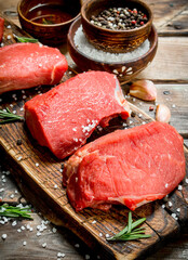 Raw meat. Pieces of fresh beef with spices and herbs .