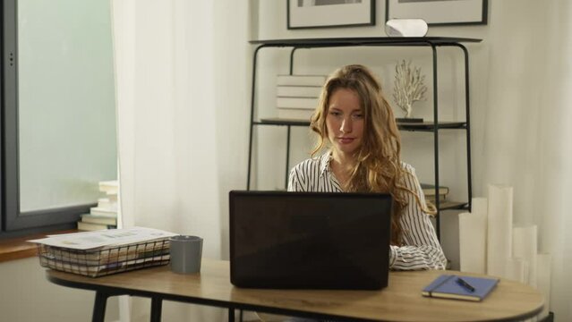 Slow motion video of a woman working at a computer from home. A girl clicks on a laptop keyboard while working remotely online. A businesswoman is preparing a report. High quality 4k footage