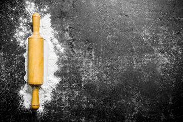 Flour with a wooden rolling pin.