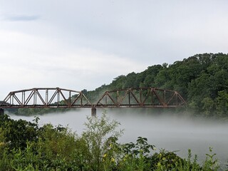 old train bridge over foggy river