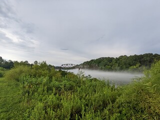 Rail bridge over foggy river landscape
