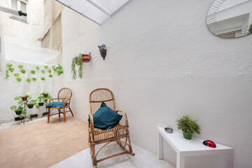 Interior patio of a house with white painted walls and rocking hammocks made of bamboo and fiber