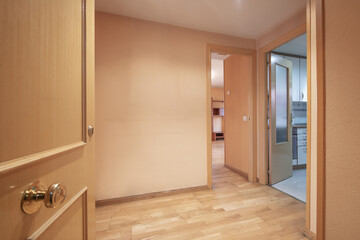 Entrance hall of a house with a beech wood door and access to several rooms with doors of the same...
