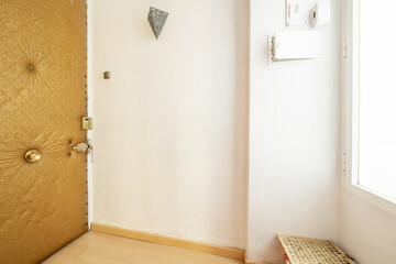 Entrance hall of a house with a vintage-style upholstered door and a white aluminum window