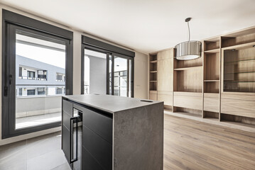 Apartment with kitchen open to the living room with custom-made oak bookcase and windows with...