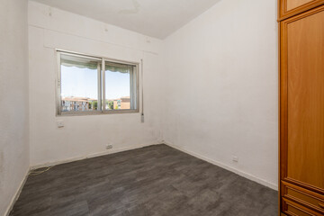 empty room with white walls and gray sintasol parquet floors and aluminum double window