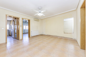 empty room with yellow walls and light brown stoneware floor and access to other rooms with oak doors