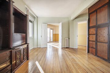 Empty home with some loose wooden furniture with mahogany bookcase and hardwood floors