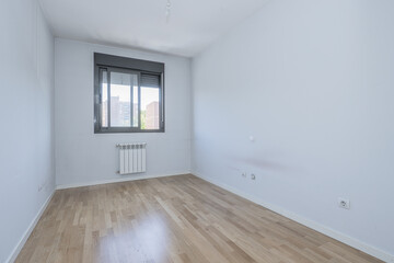 empty room with white walls and oak parquet flooring and ocher color anodized aluminum double window