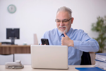 Old male employee working in the office