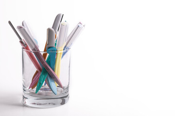 multi-colored women's shaving razors in glass isolated on white background. Space for text.