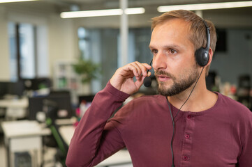 Caucasian bearded man with a headset. Male call center worker