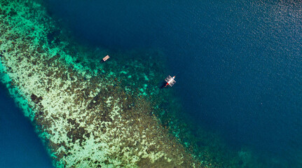 Fototapeta na wymiar Catamaran Sailing Near Shallow Coral Reef In The Ocean In Palawan, Philippines