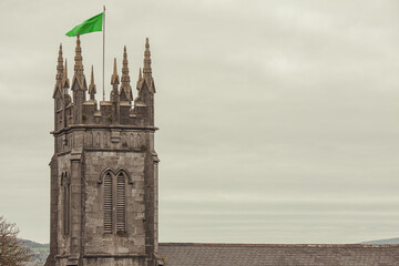 Discover Ireland concept. Top view to tower of Saint Munchin's Church in Limerick city. Clouds in the sky. Text space. Postcard style. Outdoor shot.
