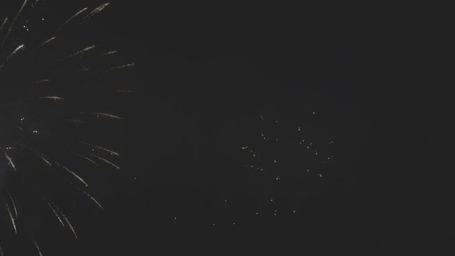 Colorful fireworks festival. Beautiful sparkling fireworks in slow motion. Wonderful real fireworks in the night sky shot with a telephoto lens. 4K 120fps video, ProRes 422, 10 bit ungraded C-LOG.