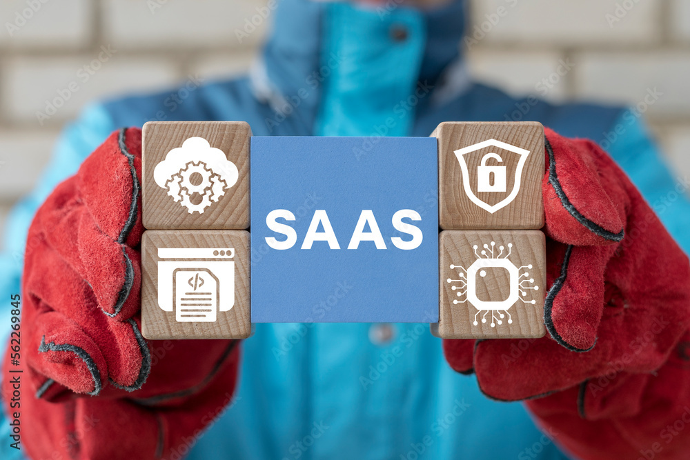 Poster industrial engineer holding colorful blocks with banner: saas. software as a service (saas) concept.