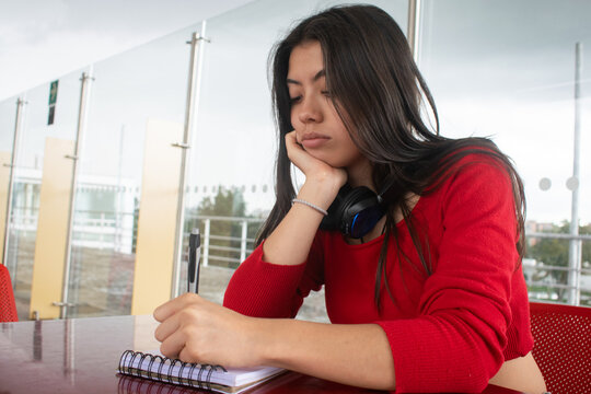 Chica universitaria escribiendo al aire libre en la terraza