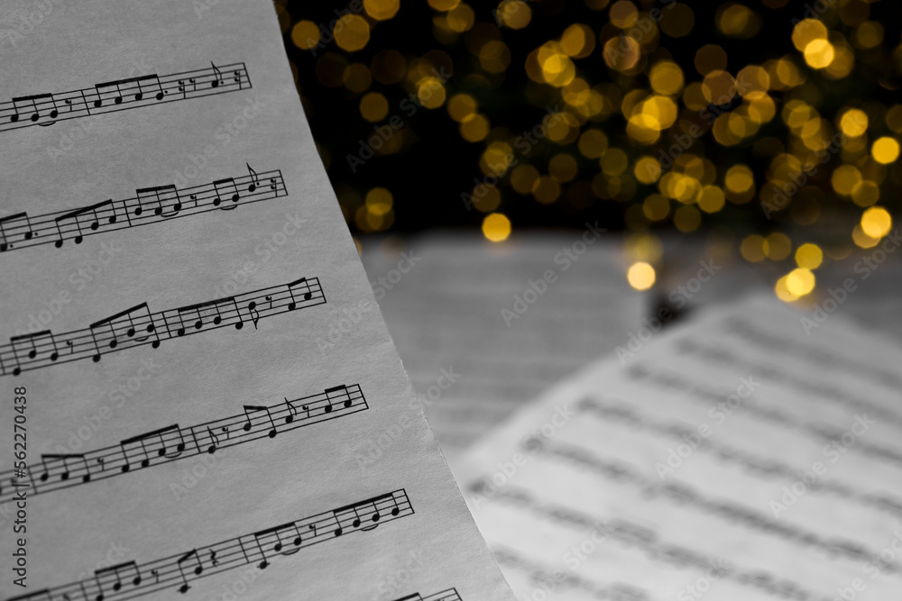 Poster Closeup view of note sheet against blurred lights. Christmas music