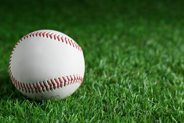 Baseball ball on green grass, closeup with space for text. Sports game