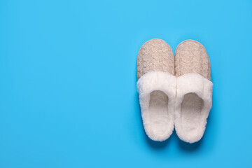 Pair of beautiful soft slippers on light blue background, top view. Space for text