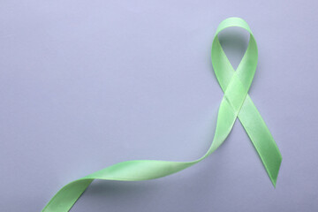 World Mental Health Day. Green ribbon on color background, top view with space for text