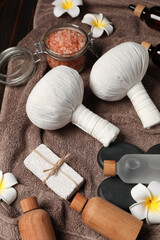 Fototapeta na wymiar Herbal massage bags and other spa products on wooden table