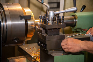 The machine operator working with lathe machine.