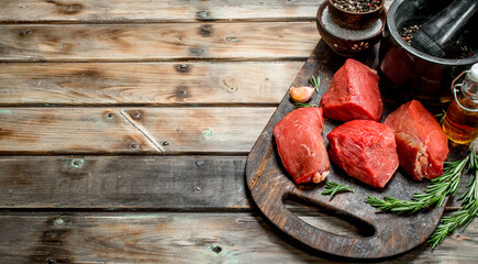 Raw meat. Pieces of fresh beef with spices and herbs .