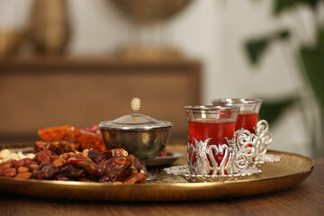 Glasses with tasty Turkish tea and oriental sweets on wooden table indoors, space for text