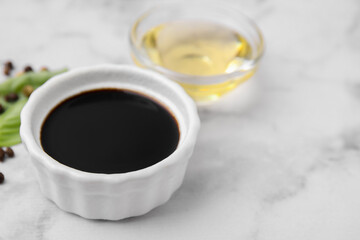 Bowl with balsamic vinegar on white table, closeup. Space for text