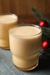 Glasses of delicious eggnog on table, closeup