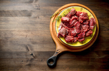 Cut raw beef in a bowl of thyme.