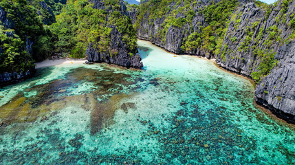The Big Lagoon In El Nido, Palawan, Philippines. Kayaking In Shallow Crystal Clear Water, Turquoise Colored Reef, Bright Green Tree Covering Cliffs. Reef and Channel