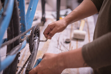 Man's hands tightening a crank of a bicycle